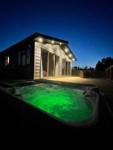 约克Hollicarrs - Dragonfly Lodge的一座房子前的游泳池,里面装有绿色液体