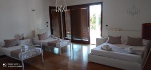 加利波利Villetta Del Salento Exclusive B&B的客厅配有2张床和椅子以及吊灯。