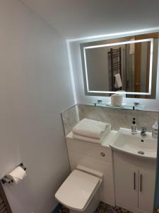 布里克瑟姆Harbour View的一间带水槽、卫生间和镜子的浴室