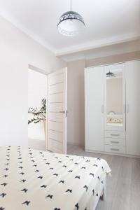 林巴日Centra apartamenti Elīza的一间白色卧室,配有一张床和一个衣柜