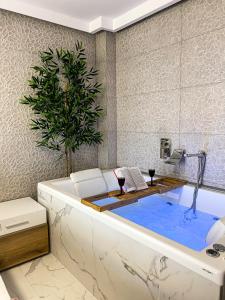 伊里斯斯Seafront Oasis Beach Houses的浴室内提供浴缸及两杯葡萄酒