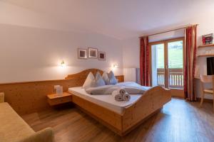 思科纳Pension-Appartement Mitterhofer的一间卧室设有一张床和一个大窗户