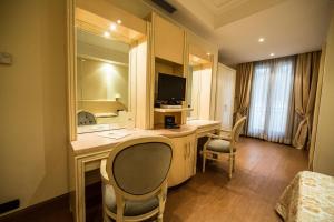 马里诺LH Hotel Domus Caesari的酒店客房配有带电视和椅子的书桌