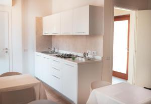 圣彼得罗镇Casa Fadda的白色的厨房配有白色的橱柜和桌子