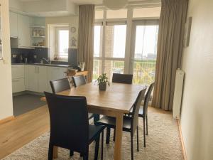 布雷斯肯斯Hello Zeeland - Appartement Port Scaldis 19-012的厨房以及带木桌和椅子的用餐室。