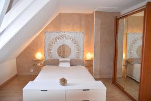ChampguyonChambres d’Hôtes Les Rougemonts的卧室配有白色的床和镜子