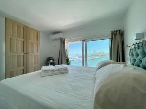 锡拉库扎Eos Sea View Apartments的卧室设有一张大白色的床和大窗户