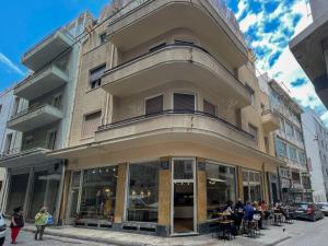 雅典Athens Designer's home 3 min to Monastiraki metro的一座建筑物,人们坐在外面街道上