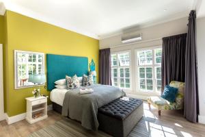 彼得马里茨堡Taunton Manor的一间卧室配有一张蓝色和黄色墙壁的床