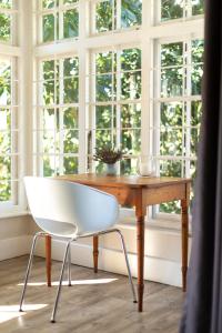 彼得马里茨堡Taunton Manor的窗前木桌边的白色椅子