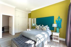 彼得马里茨堡Taunton Manor的一间卧室设有一张床,墙壁为蓝色和黄色
