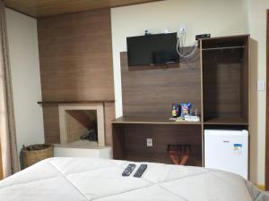 维奥康德马奥Chalés do Pardal的一间卧室配有一张床,墙上配有电视