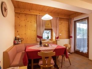 博萨迪法萨Ciasa Lino Aloch的一间用餐室,配有红色的桌子和椅子