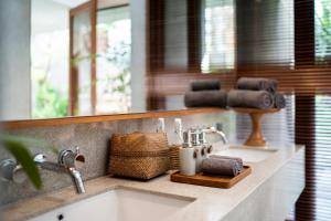 坎古Blossom Eco Luxe Villas by Ekosistem的浴室的柜台设有水槽和镜子