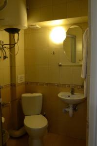 利沃夫Burger Plus Inn的浴室配有卫生间、水槽和灯