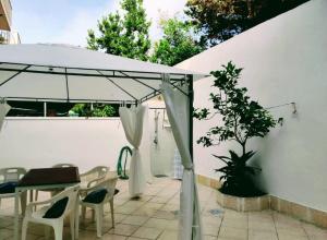 托里德欧索Casa con giardino sulla Poesia的庭院内的白色遮阳伞,配有桌椅
