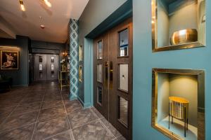 哈德斯菲尔德Stay Hotel的走廊设有蓝色的墙壁和门,铺有瓷砖地板。