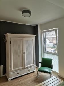 贝尔恩卡斯特尔-库斯Sonnenufer Apartment & Moselwein I的一间设有橱柜和绿椅的客房