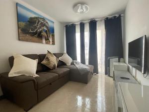 拉雷斯廷加Don Mero Pancho的客厅配有棕色沙发和电视