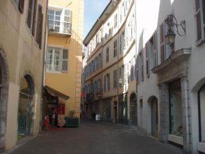 尚贝里Les Suites de Sautet的城市中一条空荡荡的街道,有建筑
