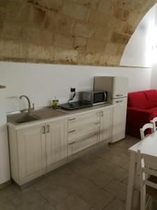 韦列La Fontana的厨房配有水槽和红色沙发