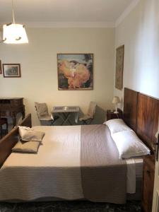圣乔瓦尼镇澳麦霍姆住宿加早餐旅馆的一间卧室配有一张大床和一张带椅子的桌子。