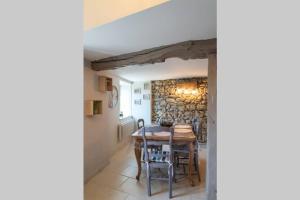 LortetLes chemins du Mont的一间设有桌椅和石墙的用餐室