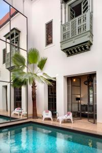 马拉喀什里亚德安塔拉旅馆的一座别墅,设有游泳池和棕榈树