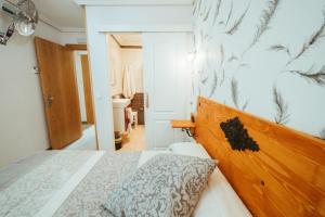莱昂Hospederia Rincon De Leon的一间卧室配有一张带木制床头板的床