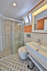 卡斯Lora Kaş Hotel的带淋浴、卫生间和盥洗盆的浴室