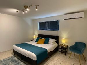 奥拉涅斯塔德Vistalmar Ocean Suites的一间卧室配有一张床和一张蓝色椅子