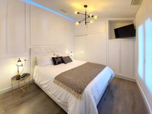 瓜迪亚纳河畔桑卢卡尔Casa Casiopea Elegante y exótica的一间白色卧室,配有一张大床和一台电视