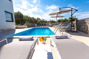 博扎瓦Luxury Apartments Mauro with Heated Pool的一个带桌子和遮阳伞的游泳池