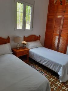 丰卡连特德拉帕尔马Casa rural Los Dragos的一间卧室配有两张床和一张带台灯的桌子