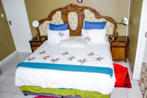 帕拉佩Motseleng Guest House的一间卧室配有一张带蓝白色枕头的大床