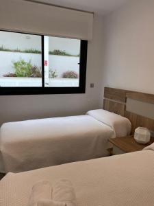 格兰阿利坎特Luxury sea view MARGOAPARTMENTS的带2扇窗户的客房内的2张床