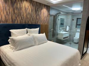 金伯利Nare Boutique Hotel的一间带白色大床的卧室和一间浴室