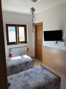 马丁纳弗兰卡Casa vacanza bella Puglia的一间卧室配有两张床和一台平面电视