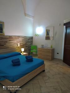阿卡亚La casa nel borgo的一间卧室配有蓝色的床和绿色椅子