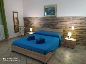 阿卡亚La casa nel borgo的一间卧室配有一张带蓝色床单的床和两盏灯。