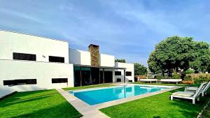 瓜达拉马Villa La Roca Madrid的庭院中带游泳池的房子