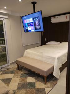 瓜鲁柳斯Flat 2211 - Guarulhos Aeroporto - Wi-fi - Estacionamento - Home Office - Shoppings的一间卧室设有两张床,墙上配有电视。