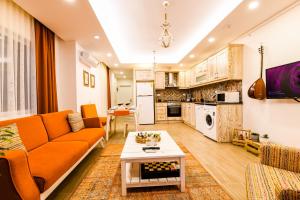 卡斯Kybele Suites的客厅配有橙色沙发和桌子