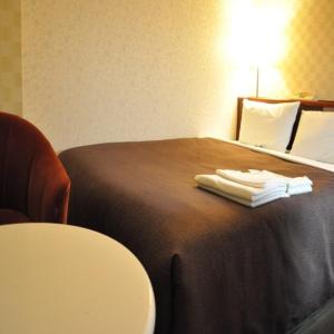 长野长野精选酒店的酒店客房,配有带毛巾的床