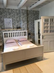 SzattaCseri Porta Kisház的卧室配有白色床和粉红色枕头。