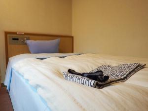大村市大村ヤスダオーシャンホテル的一张白色的床,上面有两条毛巾