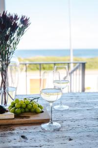 SkoenmakerskopSkoon Seaside Accommodation的两杯酒杯坐在桌子上,配葡萄