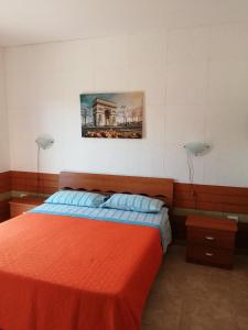托雷拉皮罗Casa Maya的卧室配有一张床,墙上挂有绘画作品