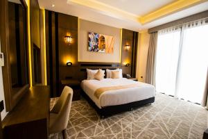塞拉莱Belad Bont Resort的配有一张床、一张书桌和一扇窗户的酒店客房