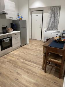 梅尔佐Rocks Appartamenti i Portici nel centro storico!的厨房铺有木地板,配有桌子。